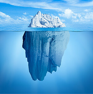 Foto eines Eisberges halb über, halb unter Wasser. Es ist zu seen, dass nur knapp 20 % des Eisberges aus dem Wasser ragen. 80 % des Eisberges liegen unter der Wasseroberfläche.