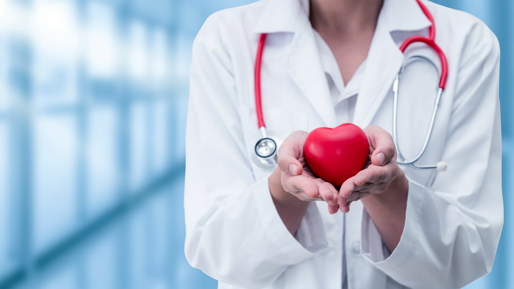 Ärztin trägt schützend ein Herz in ihren Händen und hält es in die Kamera.