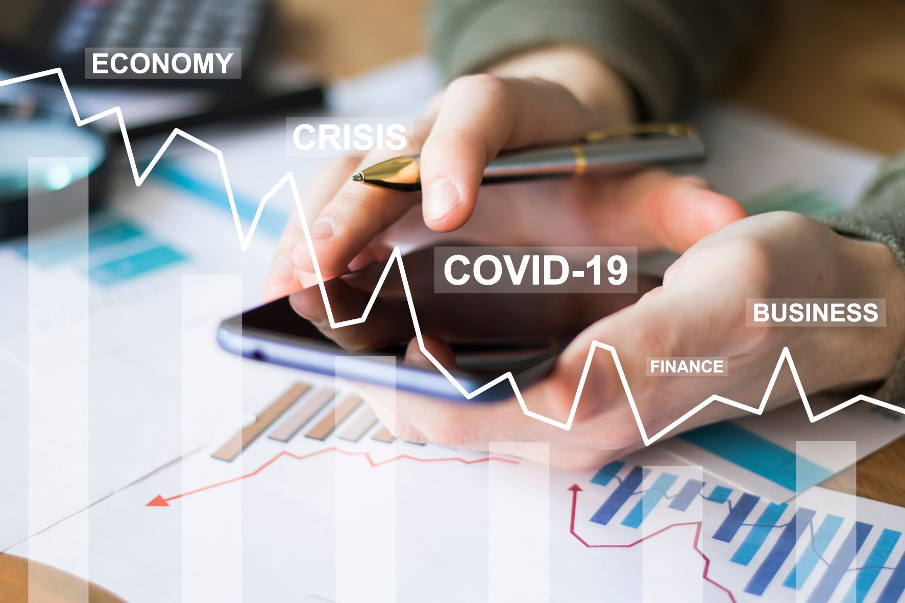 Ein Mann sitzt mit Handy und Kuli in der Hand über ausgedruckten Statistiken. Über das Foto ist ein gezeichneter Graph mit Abwärtstrend gezeichnet und mit den Worten Economy, Crisis, Covid-19, Finance, Business beschriftet.